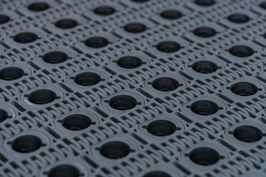 Close-up view of a grey slat belt conveyor featuring interlocking plastic segments