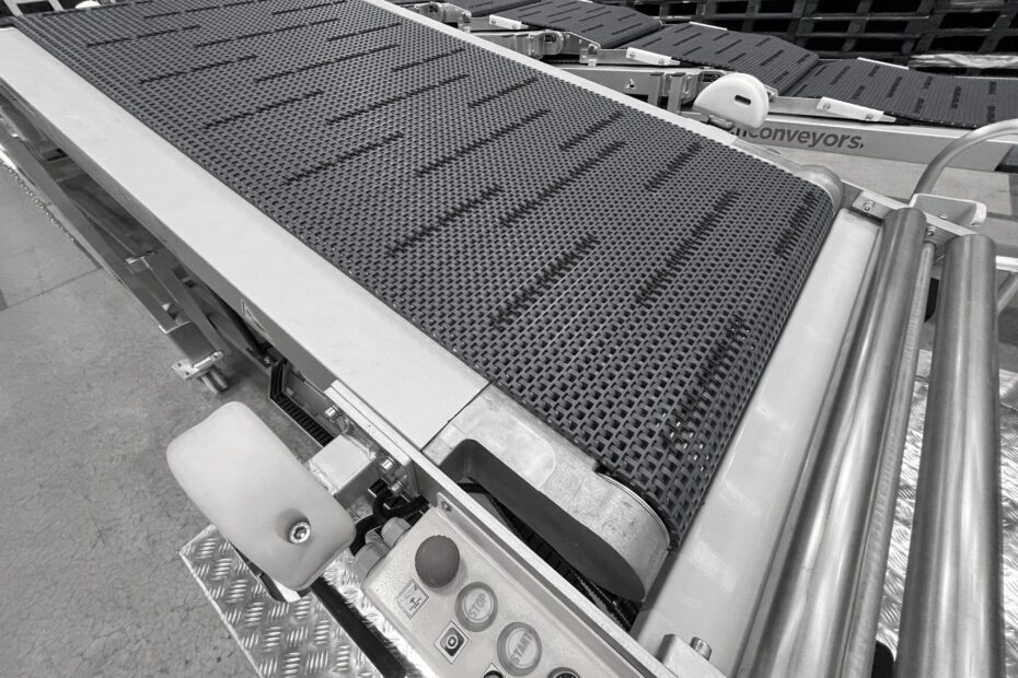 Close-up view of a telescopic conveyor belt with a textured surface and integrated control panel, designed for efficient loading and unloading in warehouse operations.
